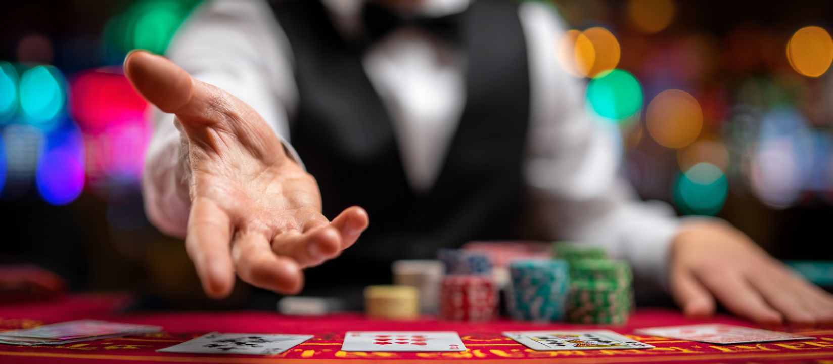 Casino dealer at PPVLP table game reaching out with poker chips and cards in view