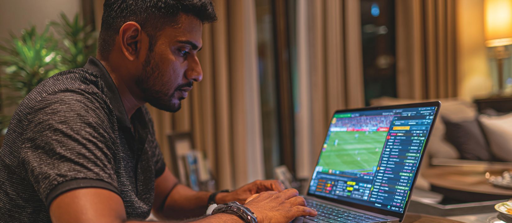 Focused man using laptop to place bets on live football through PPVLP Sports platform